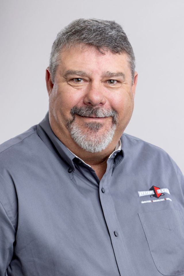 Man with grey hair, mustache and beard in grey polo