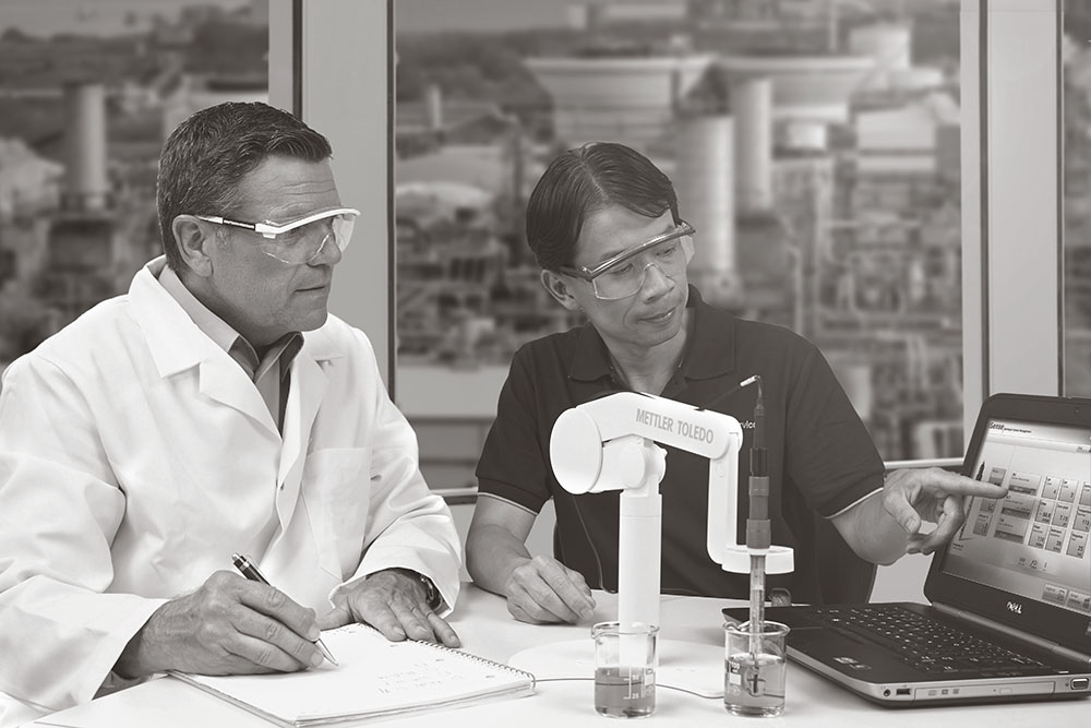 two technicians using a METTLER TOLEDO multiparameter and reviewing results on computer