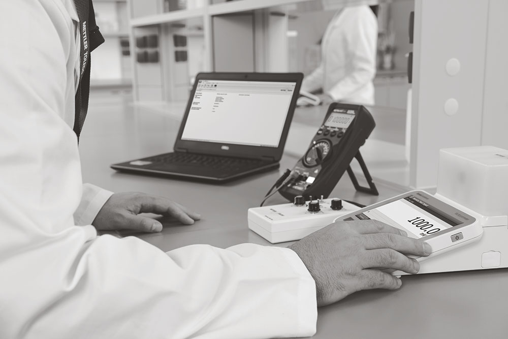 scientist using a scale in a lab with computer, lab services
