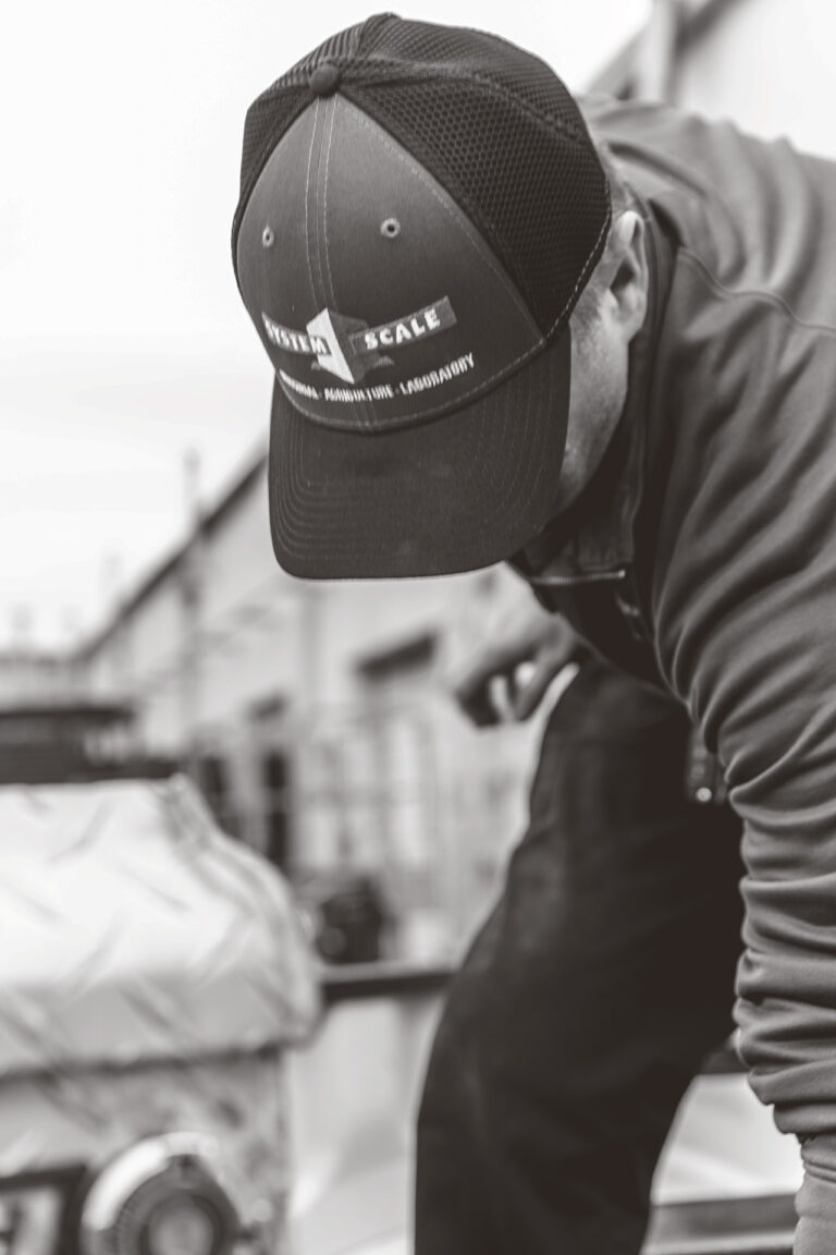 Man wearing trucker hat with prominent System Scale logo