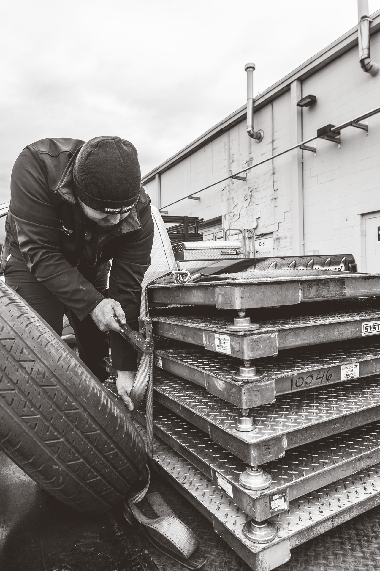 The image shows a service technician tending to a set of industrial hazardous area scales.