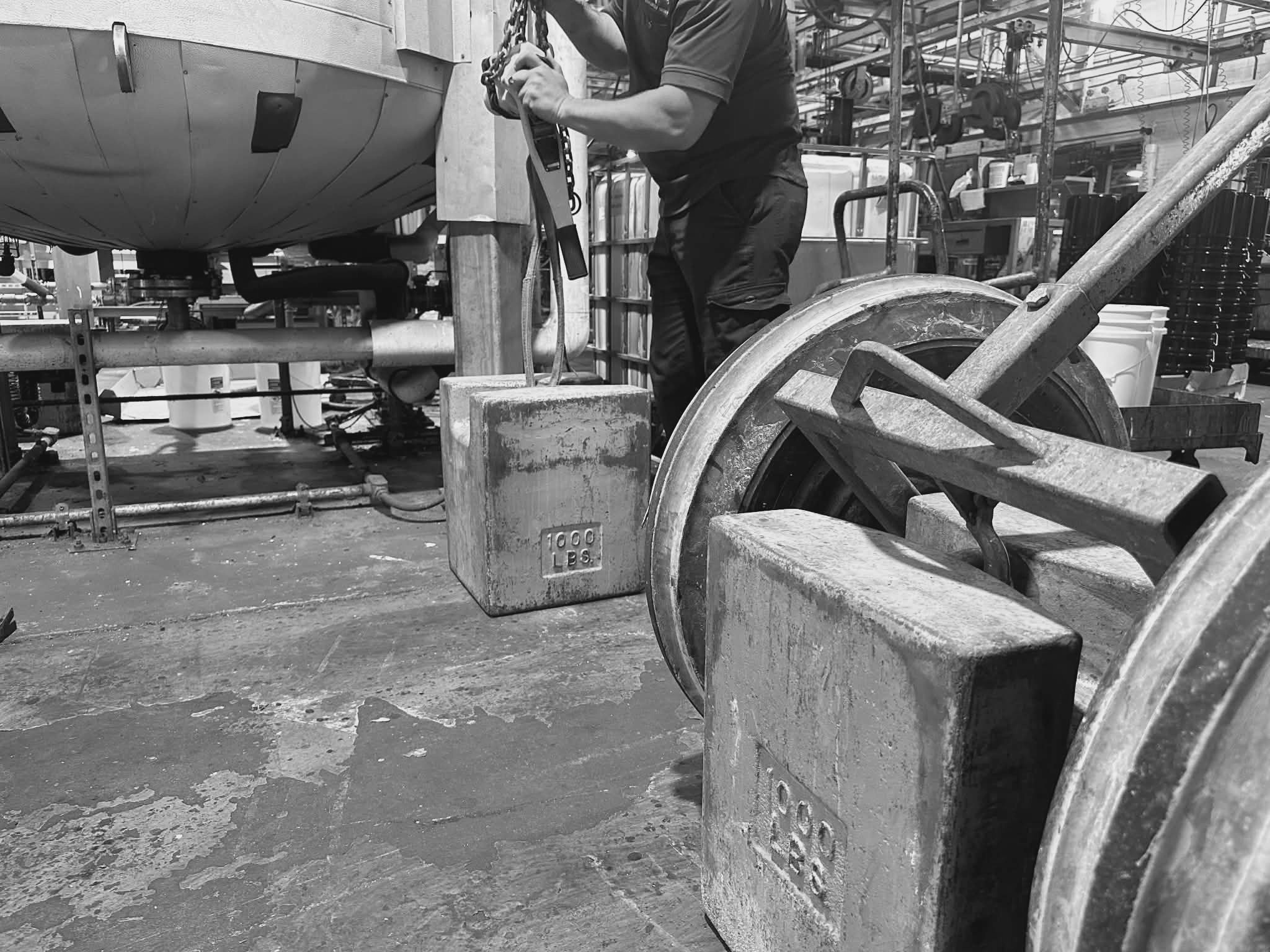 scale technician calibrating tank with weights